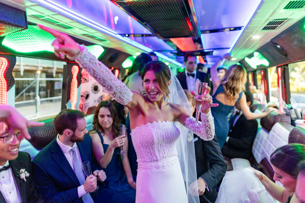 A woman in a wedding dress is dancing on a bus