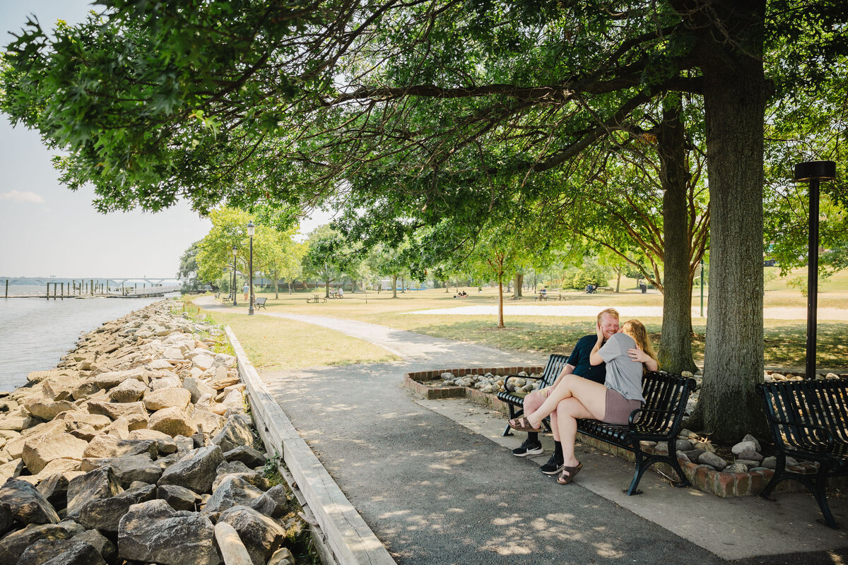 Two people sit on a bench during a proposal.