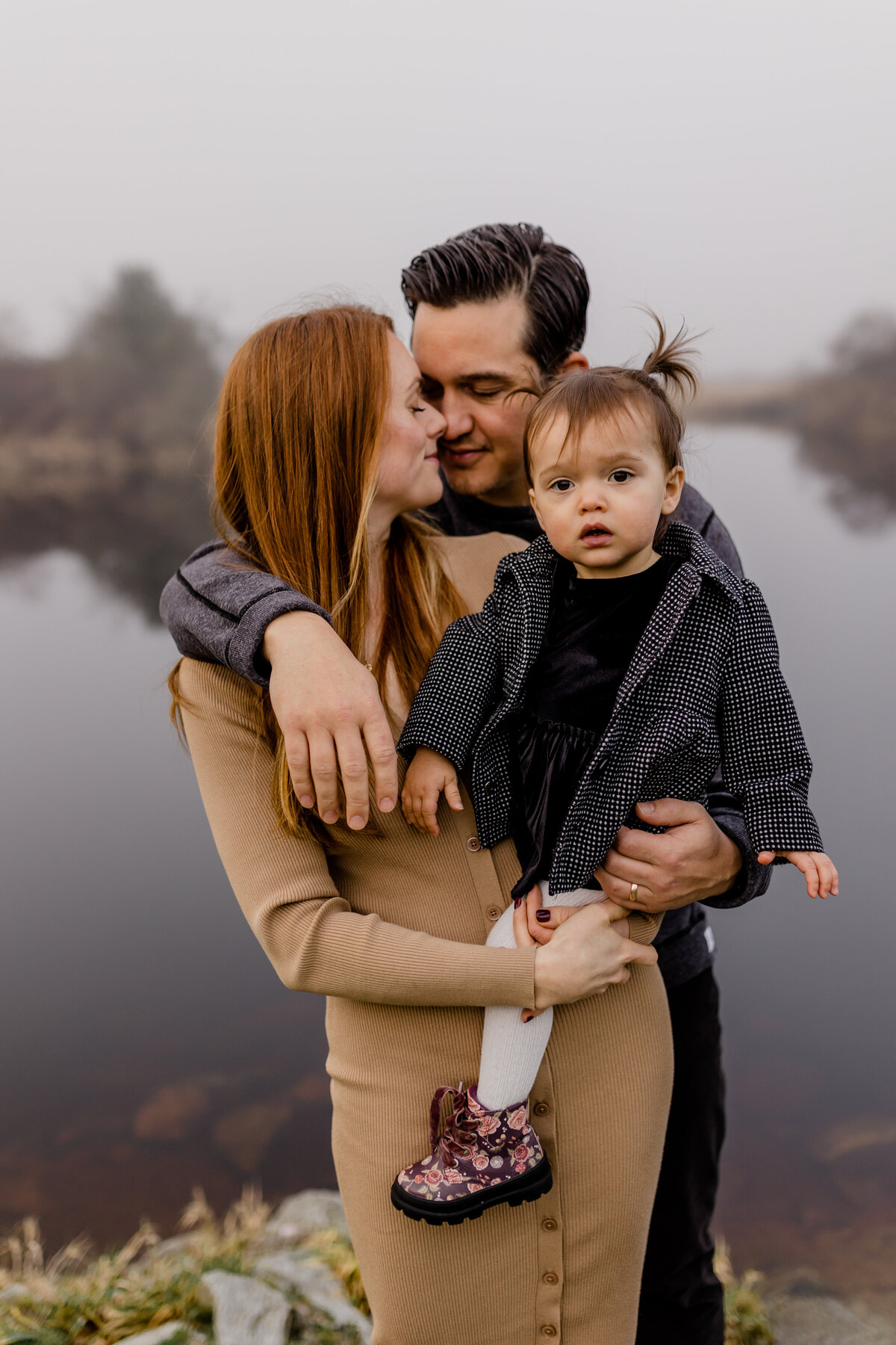 mother and father holding their daughter