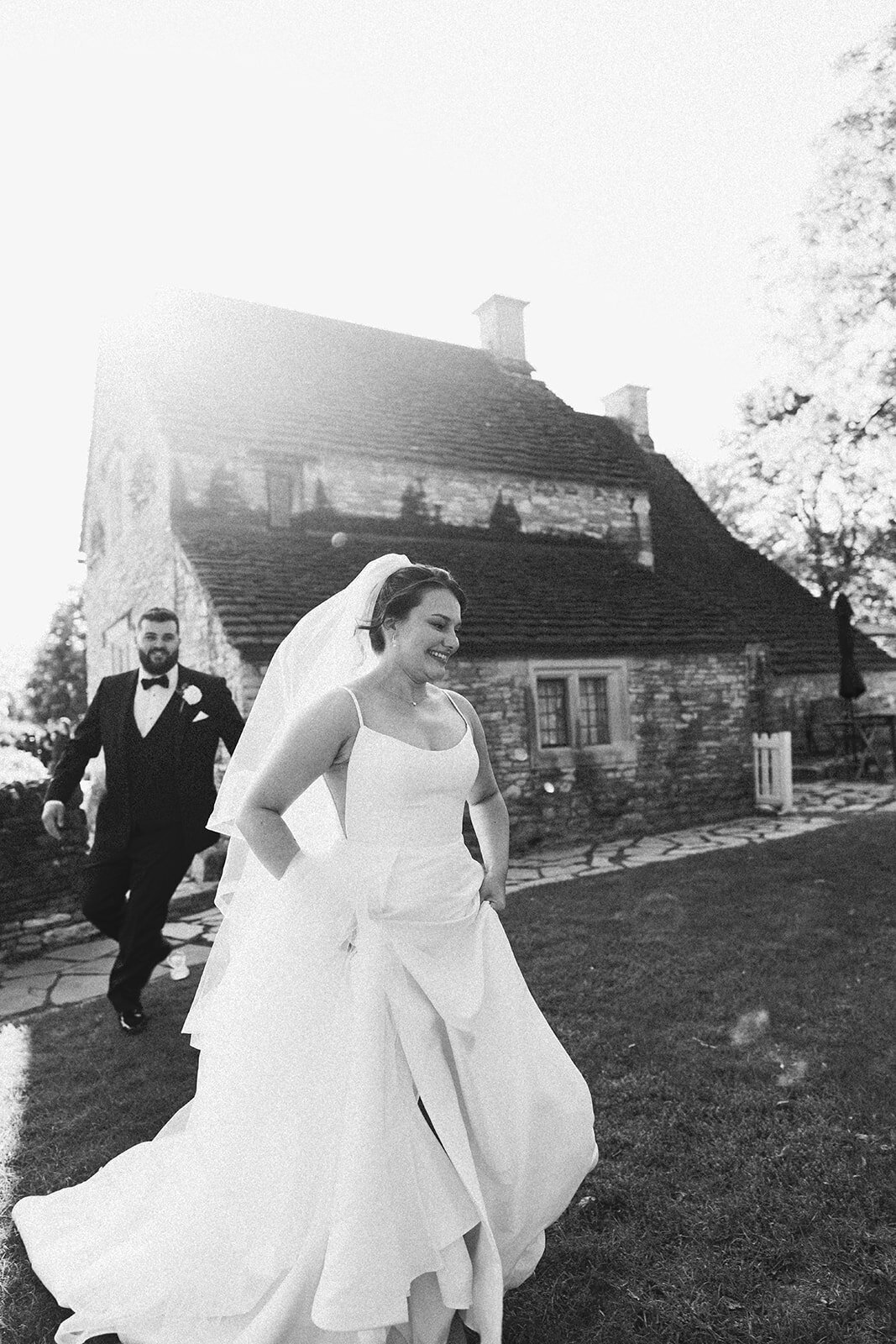 Bride and groom walking together outside the historic Martha-Mary Chapel at Greenfield Village Dearborn Michigan, romantic post-ceremony portraits.