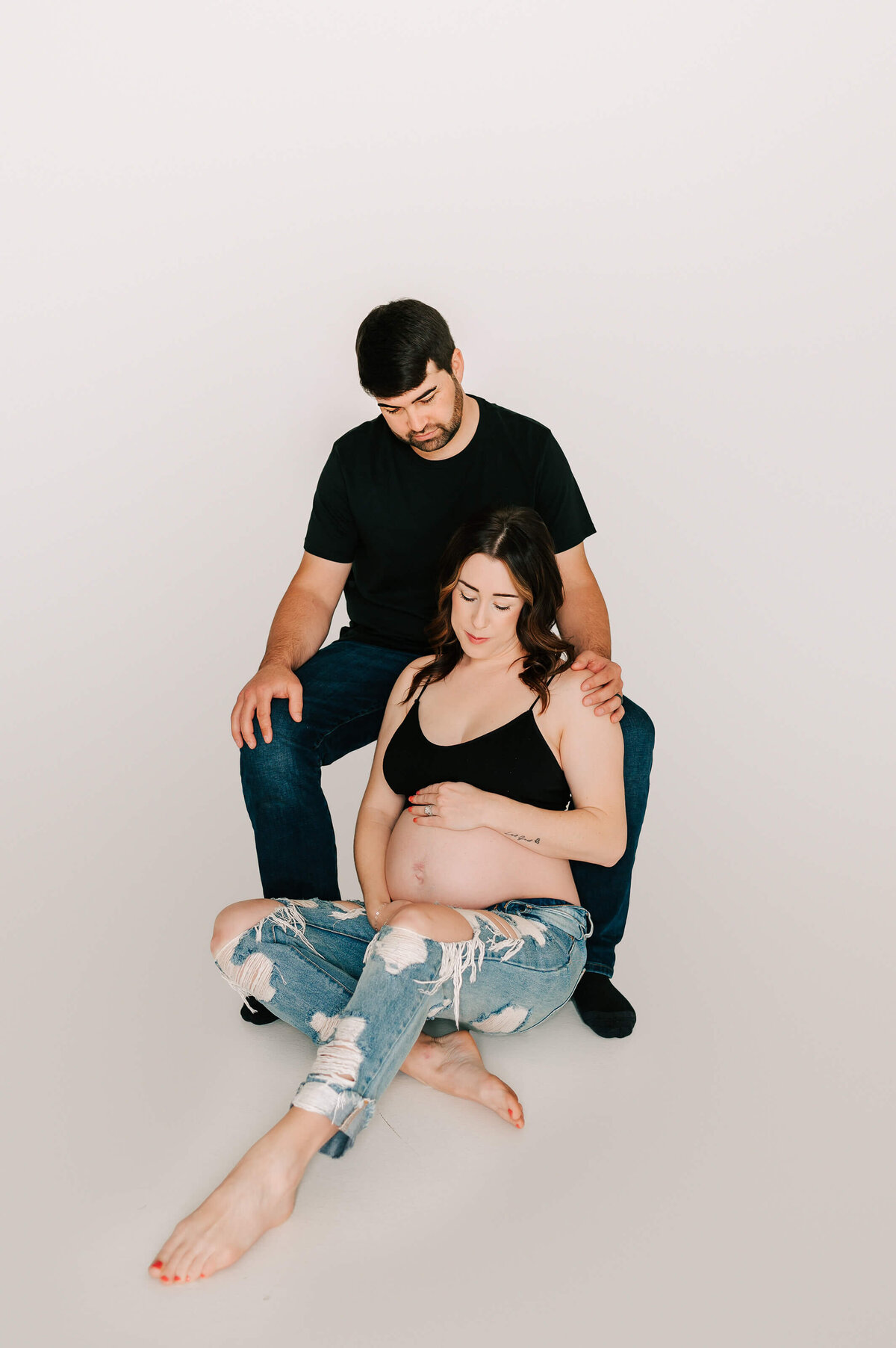 pregnant mom and dad sitting in maternity photography studio  in Springfield MO