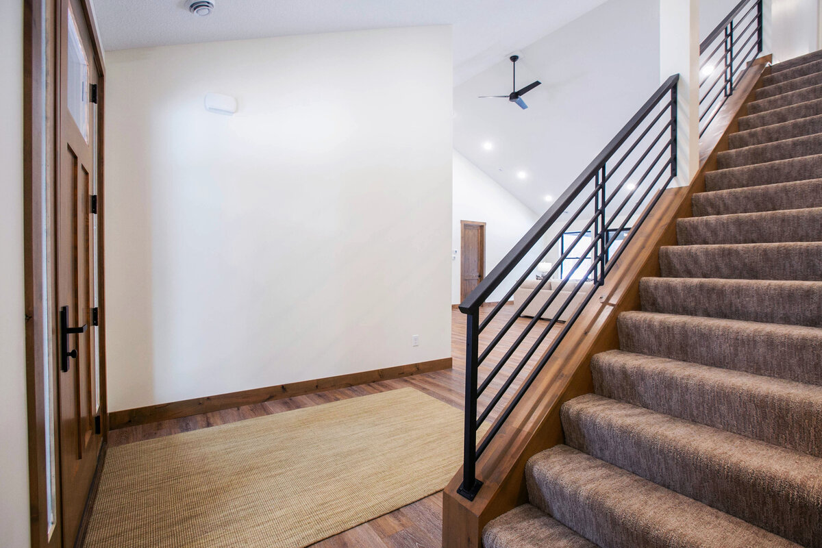 Light-filled entryway with wood flooring and neutral tones in a custom-built Elk River home