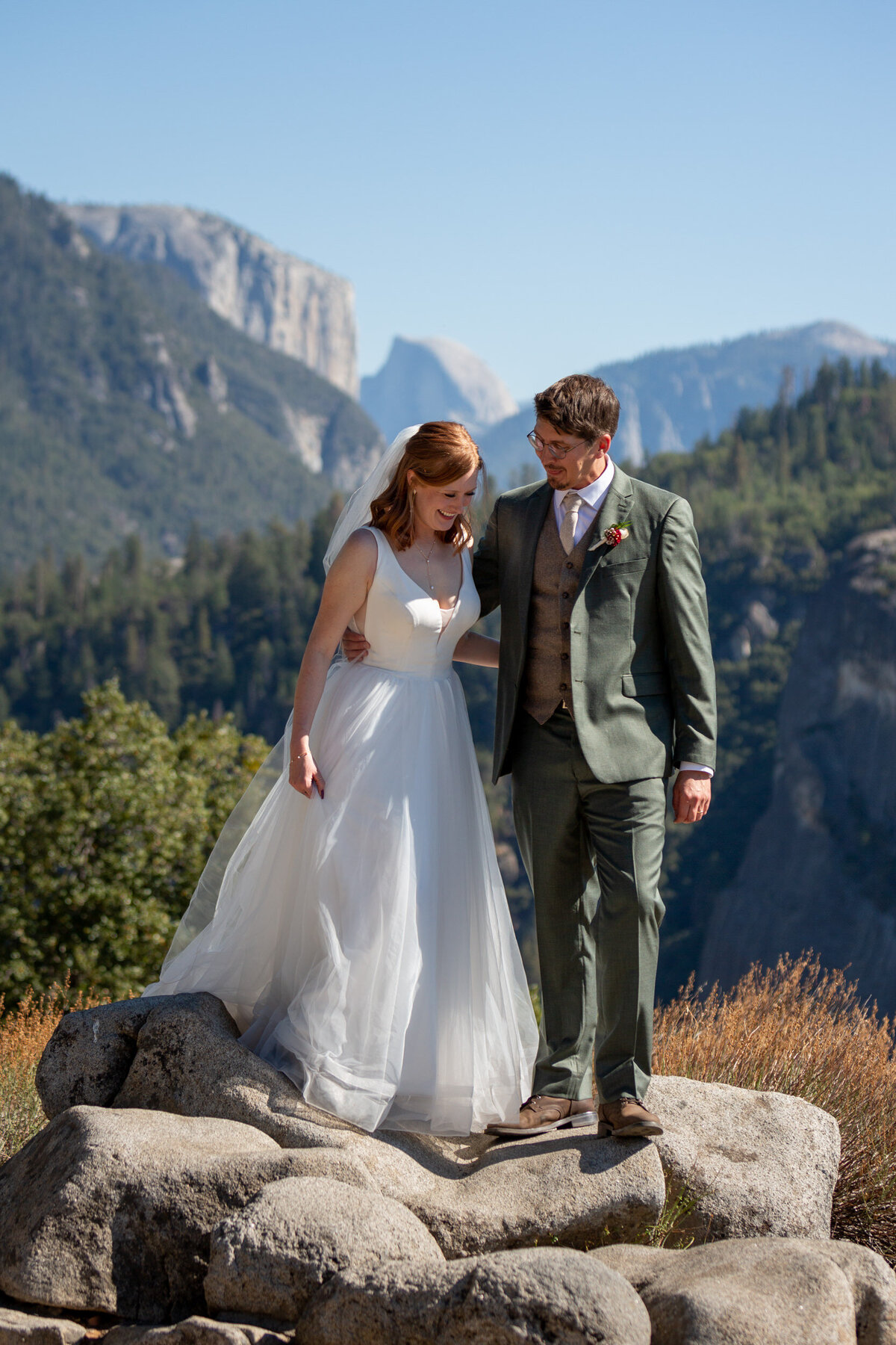 A bride and groom stand with their arms around each other, smiling, on their elopement day.