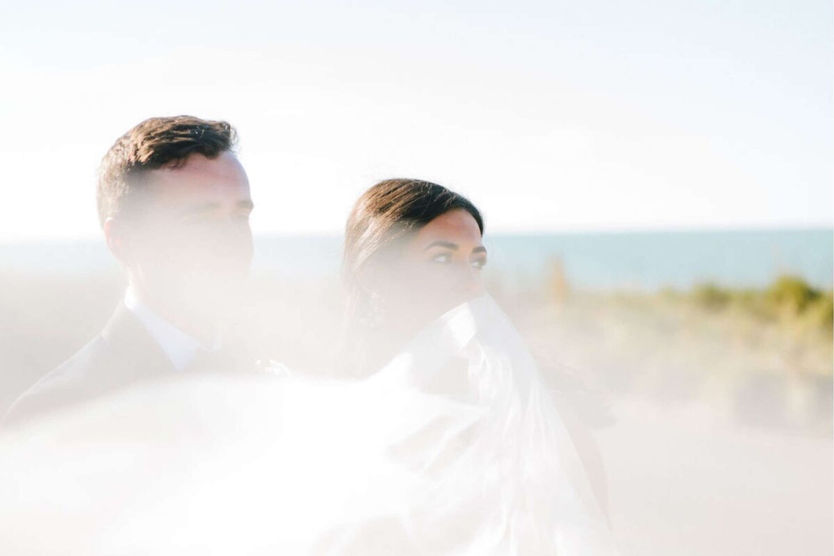 Beach Front Wedding Portraits for a Classic Bride and Groom at a Luxury Michigan Lakefront Golf Club Wedding.