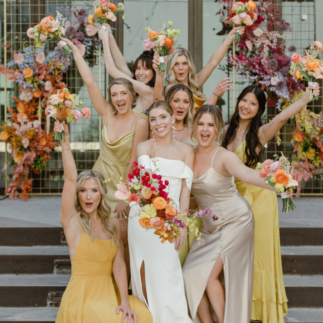 Bride and bridesmaids celebrating with bold wedding floral arrangements, showcasing Bloom Bar’s signature colorful wedding florist style in Austin.