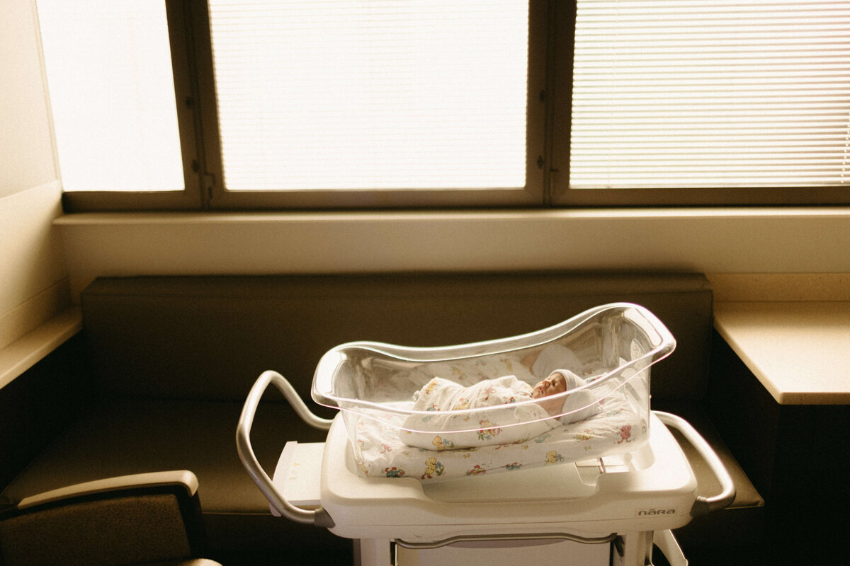 Newborn swaddled in hospital bassinet during Nashville Fresh 48 photos.