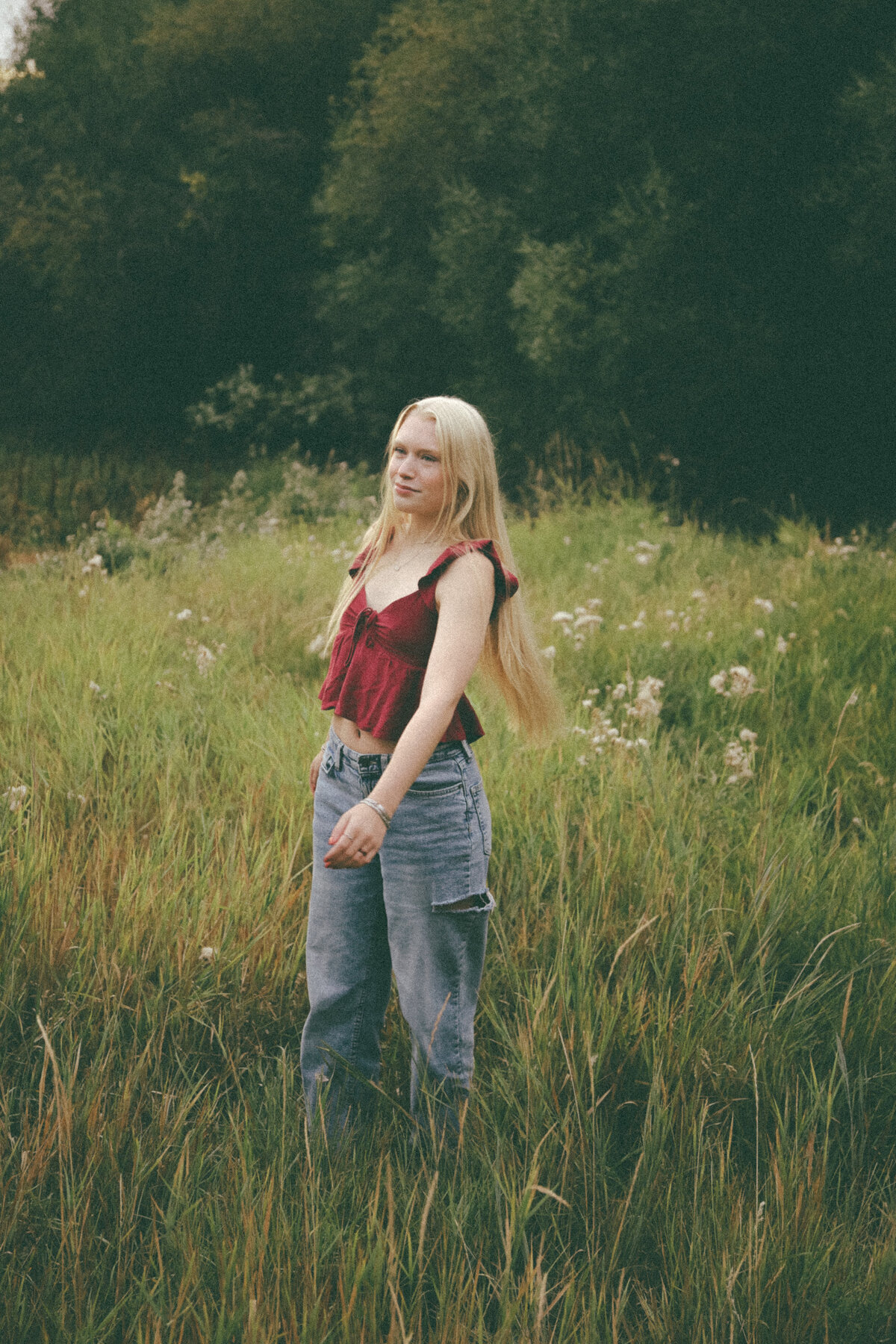 Golden Hour Senior Portrait of Girl Sitting in Meadow Surrounded by Wild Daisies in Oregon