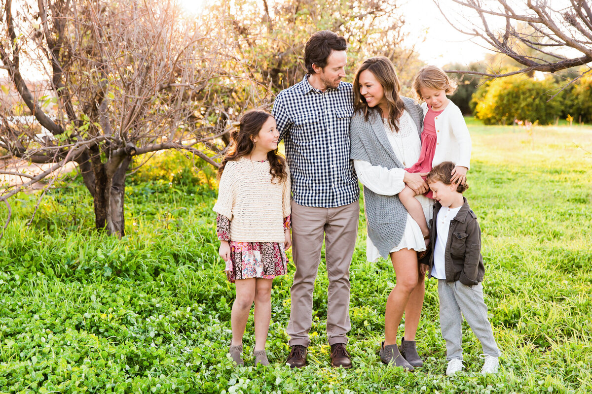 family smiling together in Gilbert orchard