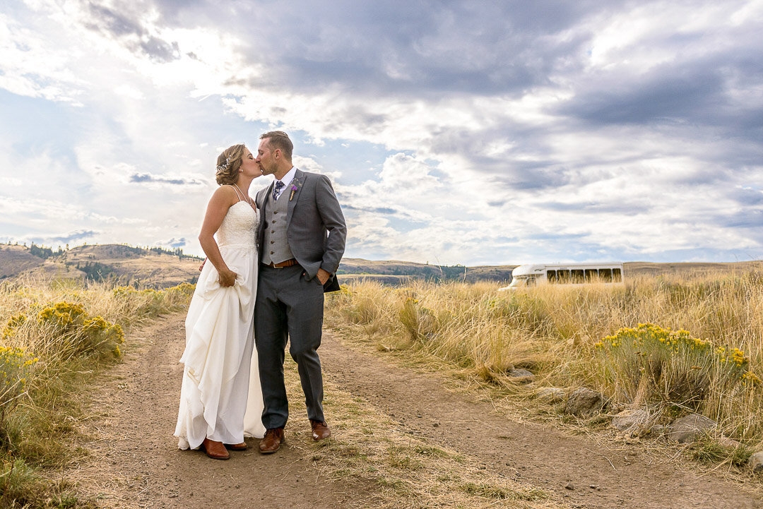 Newlyweds kissing at ranch wedding