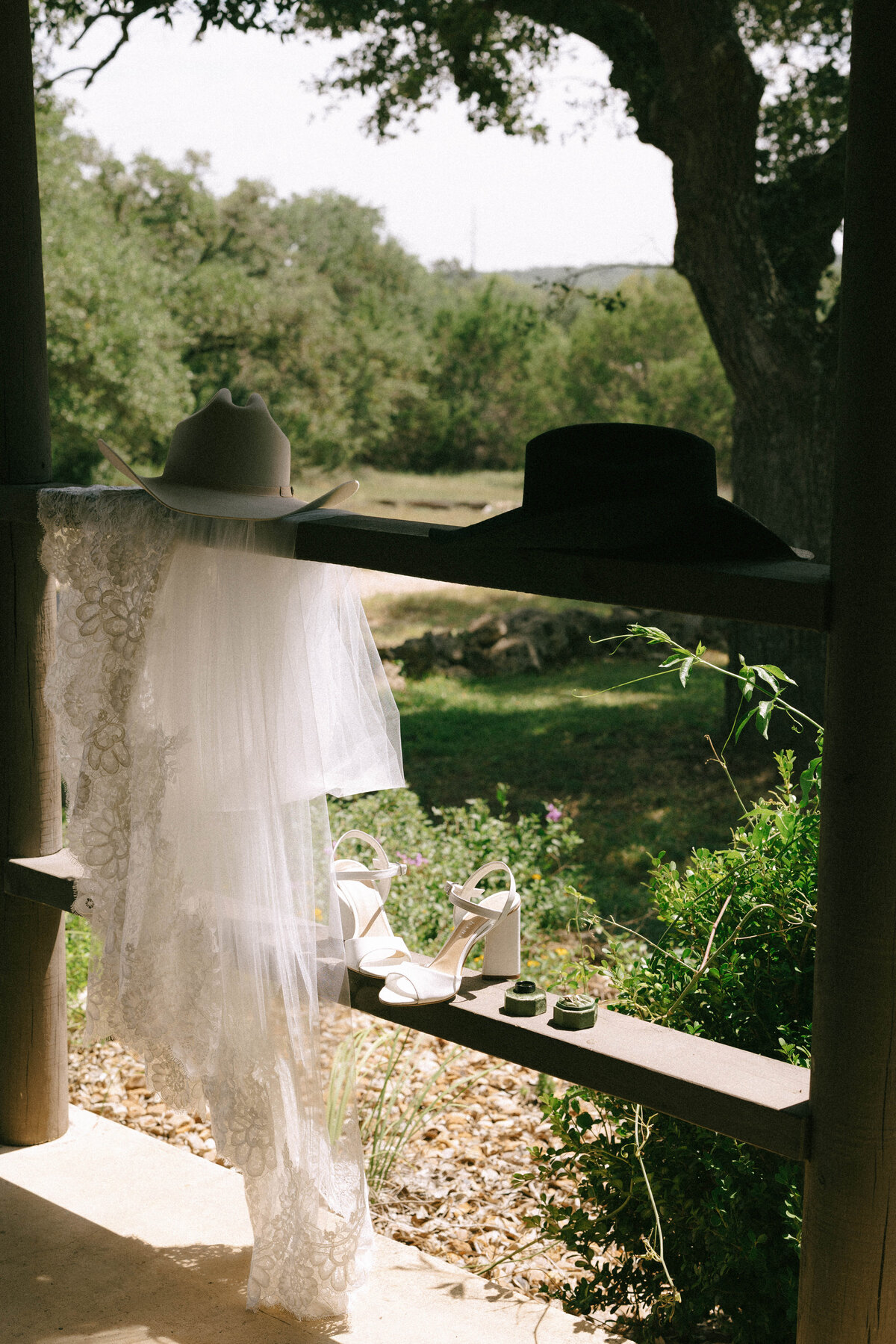 austin texas bride cowboy hat and veil sitting on rail 