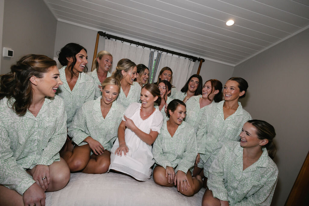 Bride surrounded by bridesmaids in matching pajamas during wedding morning at The Bascom in Highlands, NC.