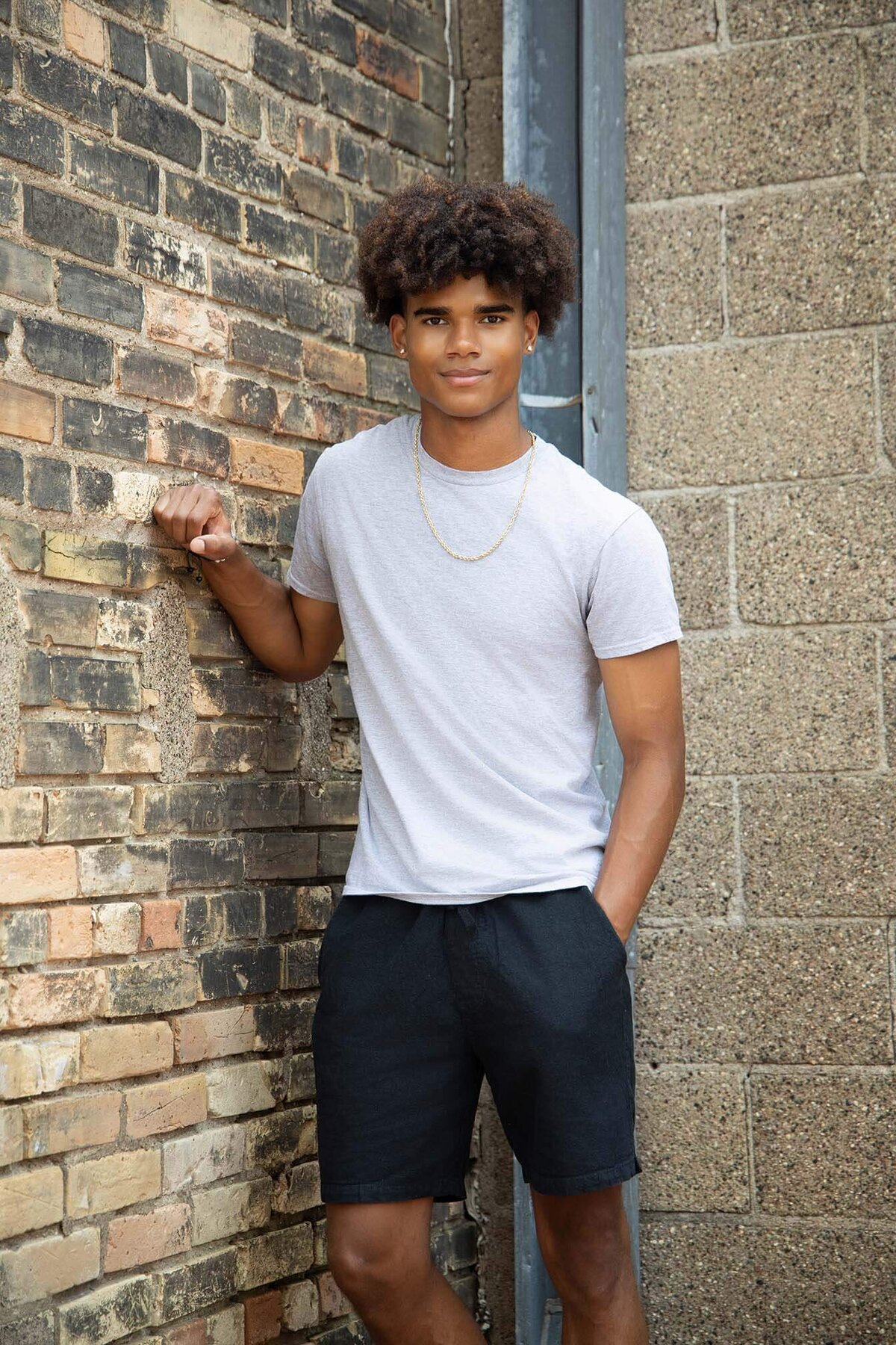 senior-boy-standing-againts-brick-wall-in-the-city