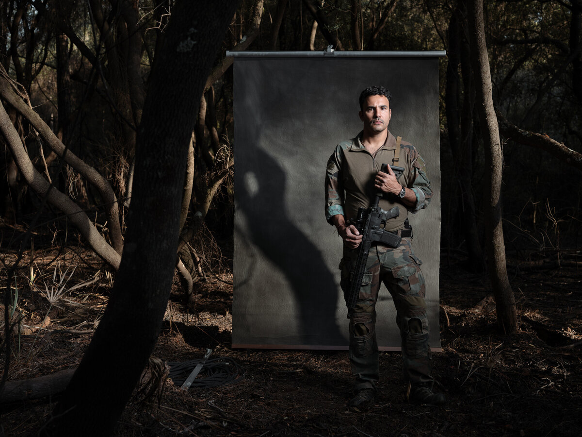 A person standing in the woods with a weapon