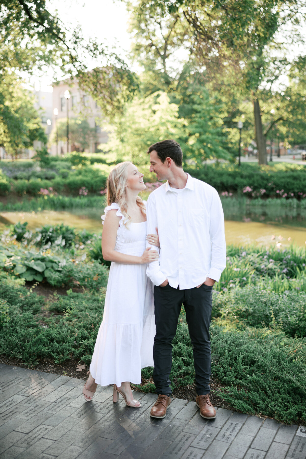 Smiling couple shares a moment during sunny engagement session in Columbus, Ohio.