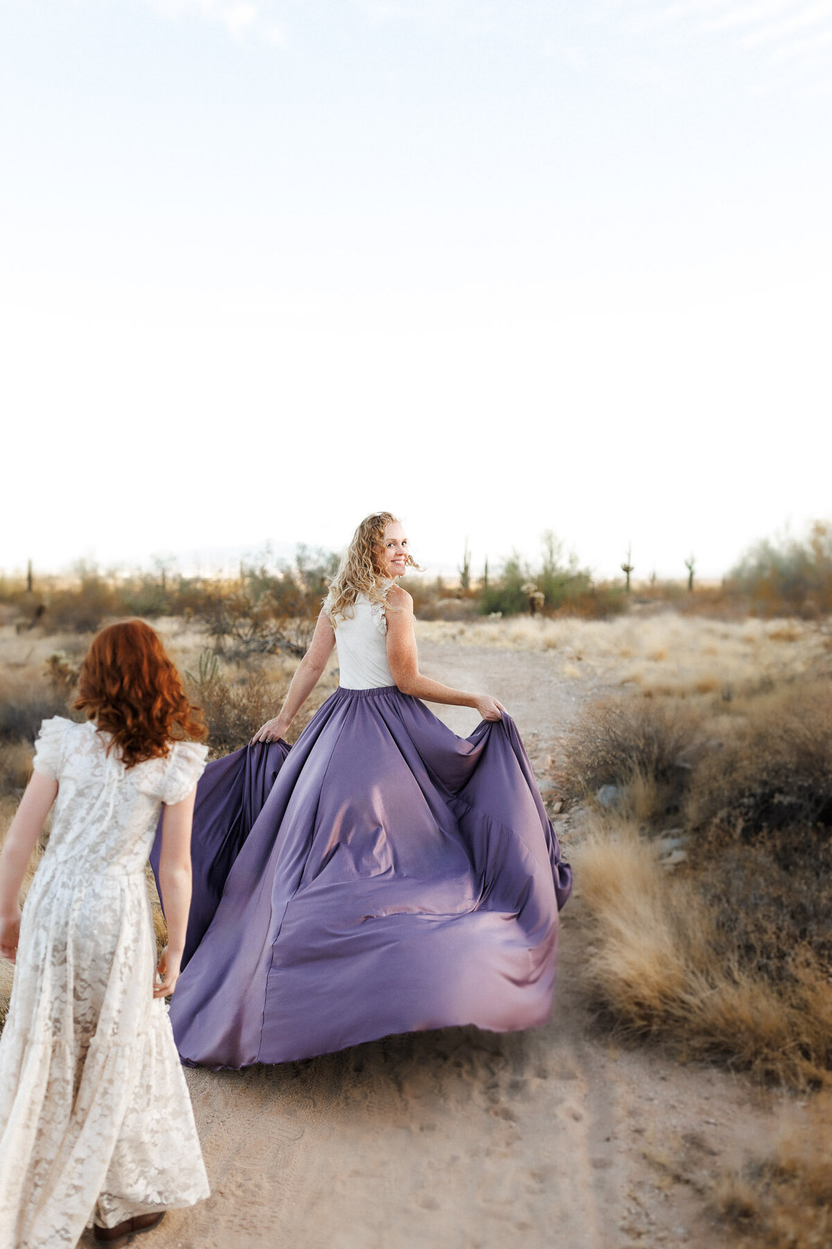 curly haired woman in long purple skirt