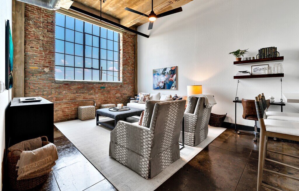 Living area with exposed brick in this three-bedroom, two-bathroom vacation rental condo in the historic Behrens building in downtown Waco, TX.