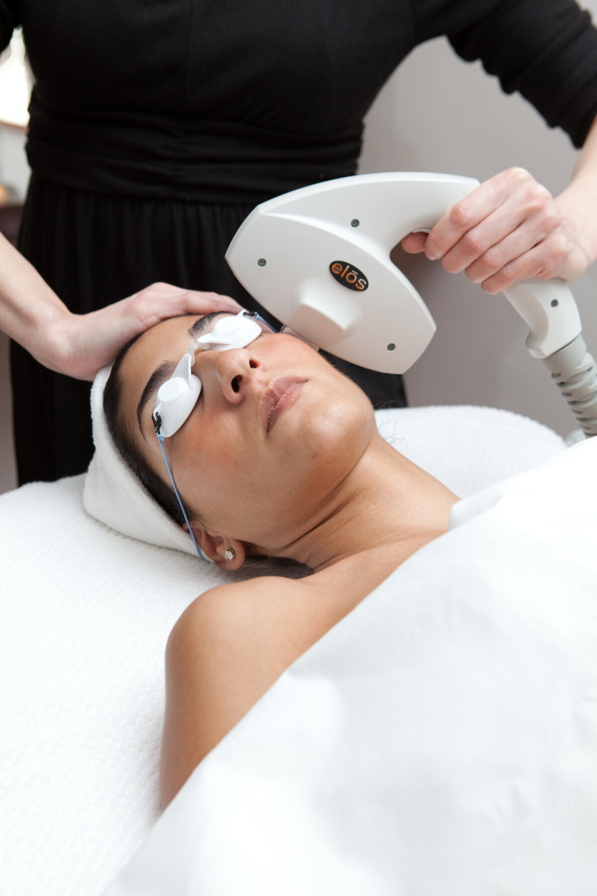 Woman with flawless skin laying on a spa bed recieving a skin treatment