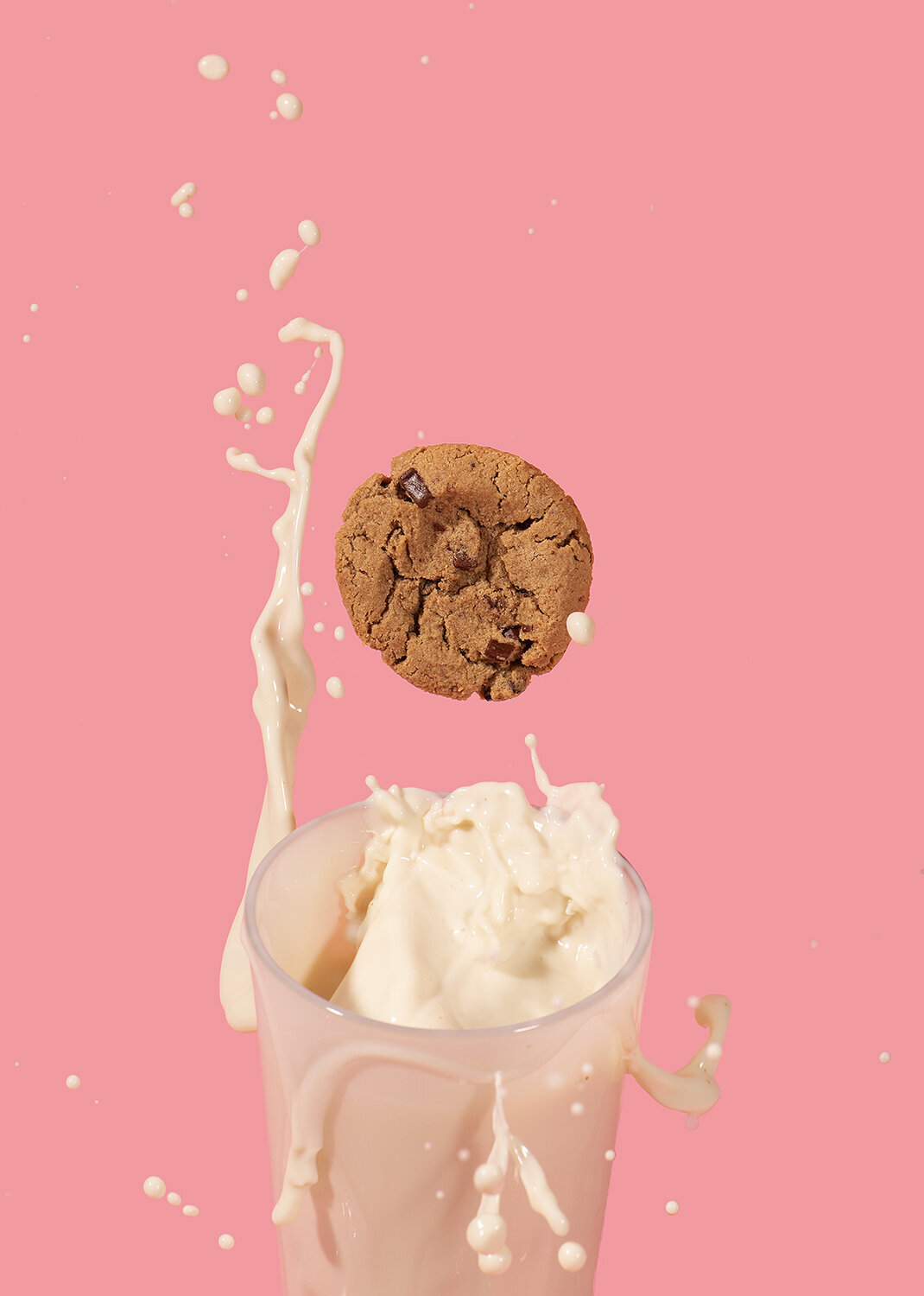 sweet lorens cookies and oatly milk splash on pink background