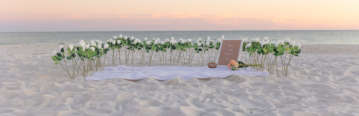 romantic setting for surprise proosal on beach with sunset in he background