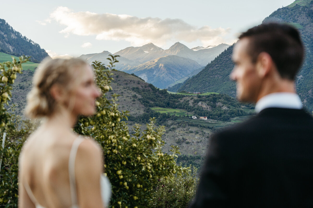Couple in orchard with mountain backdrop