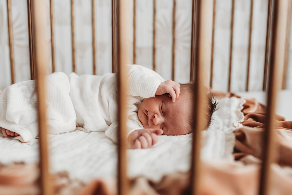 side view of baby in crib through the rails