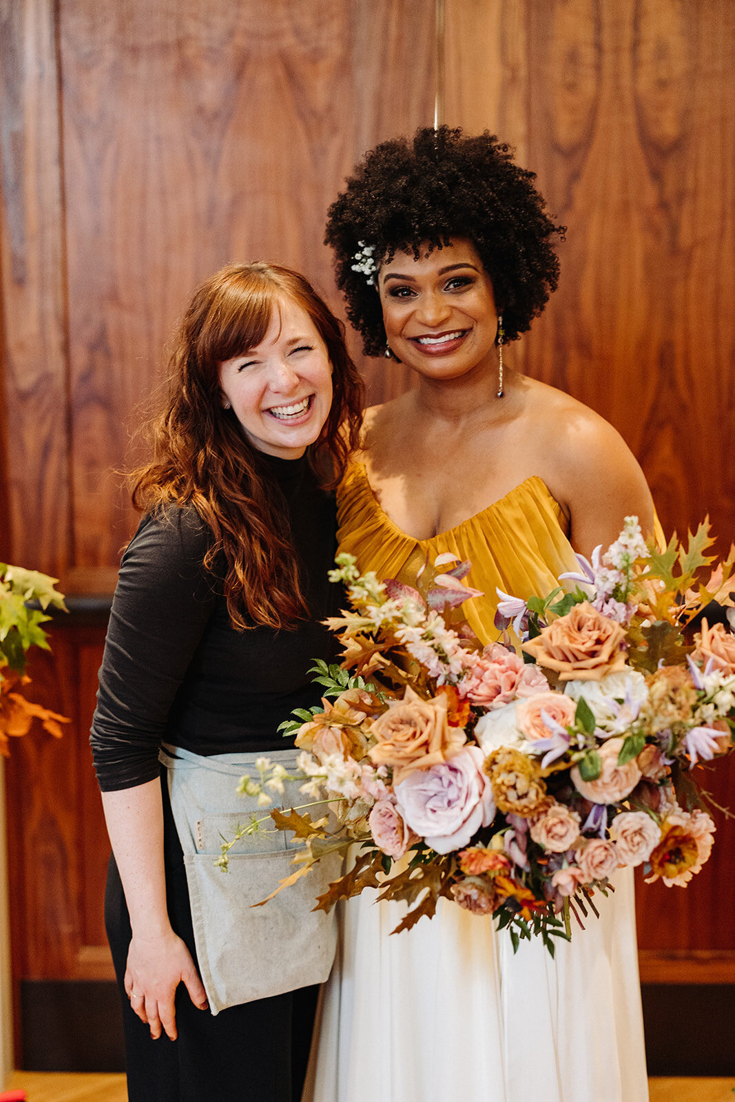 Beautiful autumnal bridal bouquet composed of roses, ranunculus, delphinium, clematis, lisianthus, and fall foliage floral hues of burnt orange, mauve, dusty rose, taupe, and lavender. Design by Rosemary and Finch in Nashville, TN.