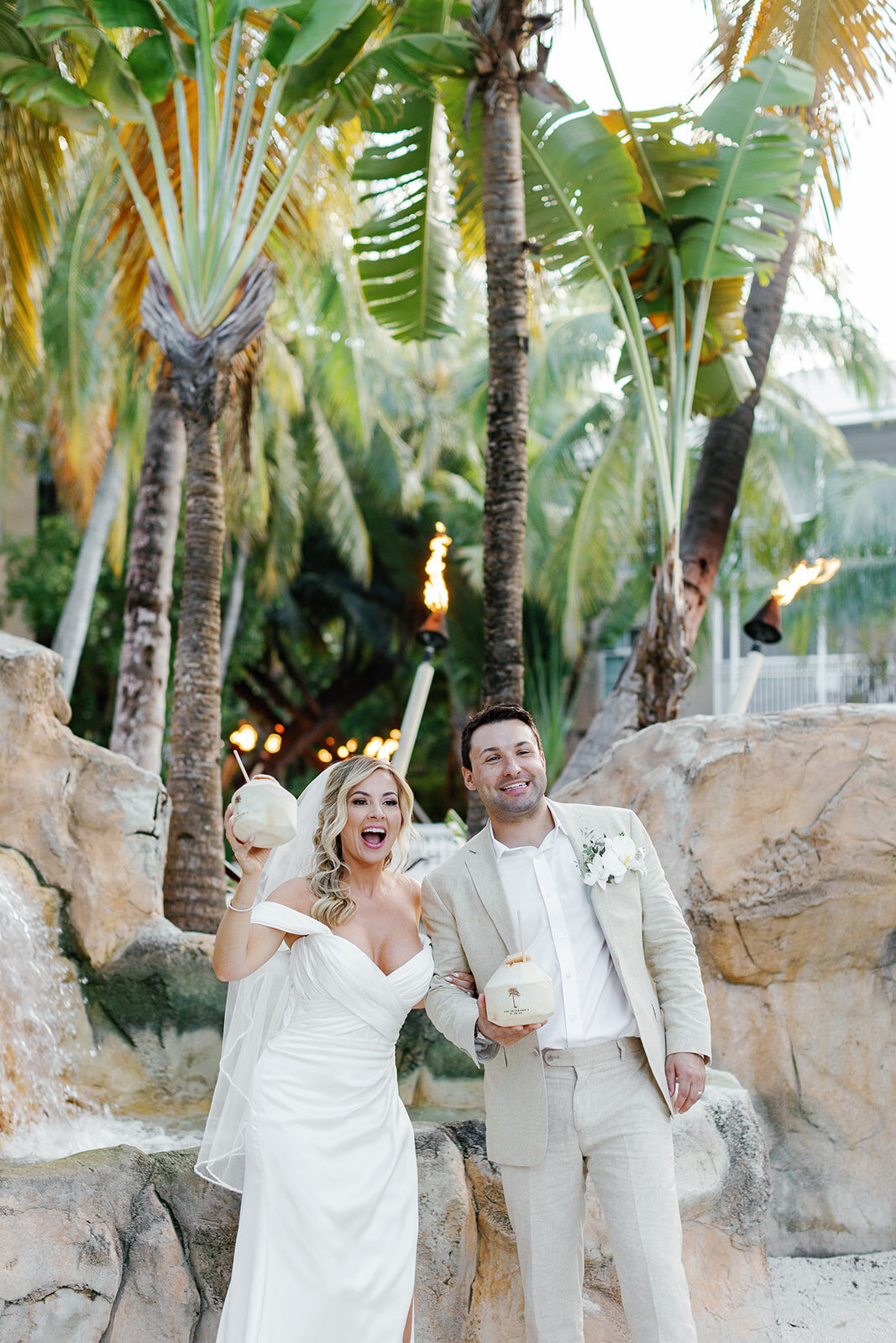 The couple cheers with fresh coconuts, a signature touch for their tropical Islamorada wedding.