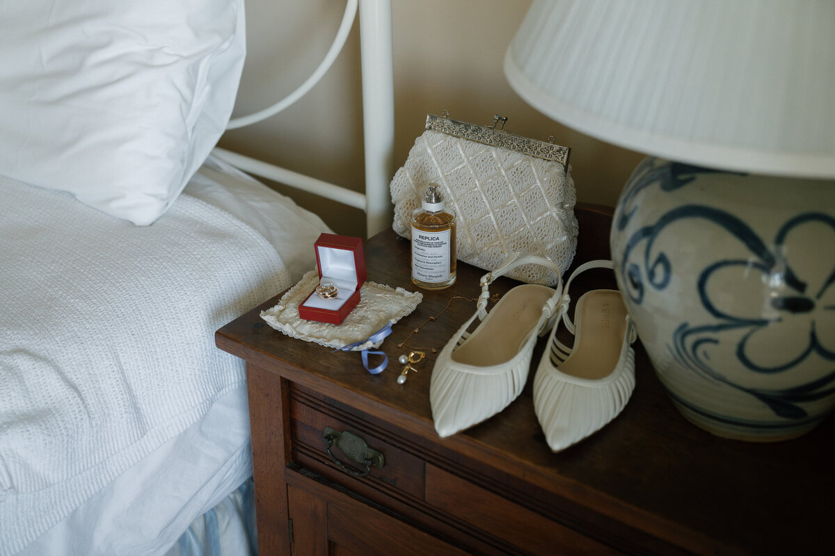 Detail photos of bride's shoes ring and perfume by film wedding photographer