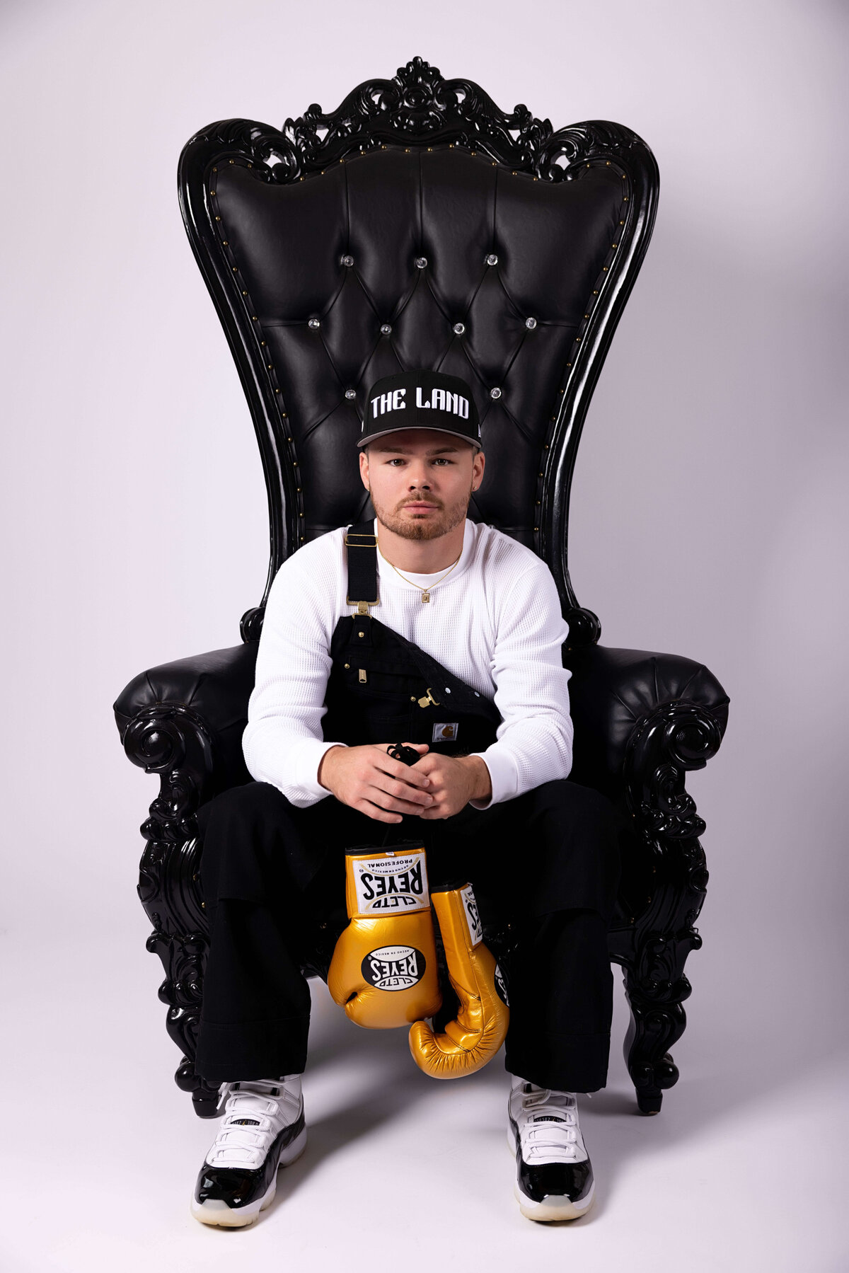 Professional boxer sitting in chair with boxing gloves in birthday session with Reva Davis photography