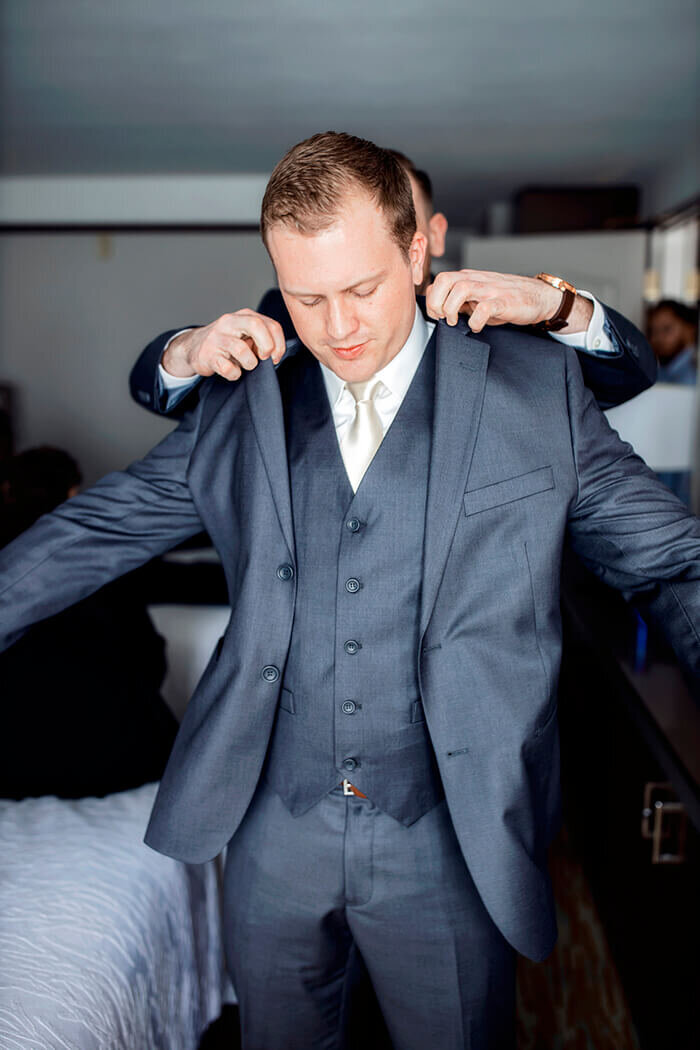 groom-puts-on-jacket