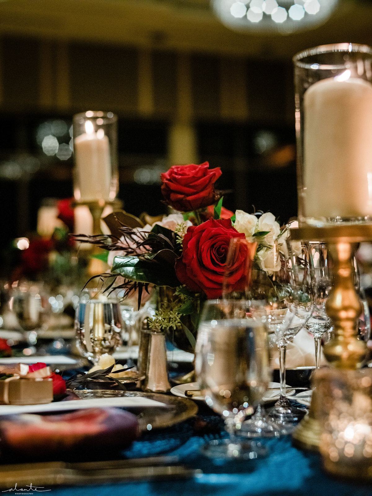 floral centerpiece detail with red roses and hurricane candles