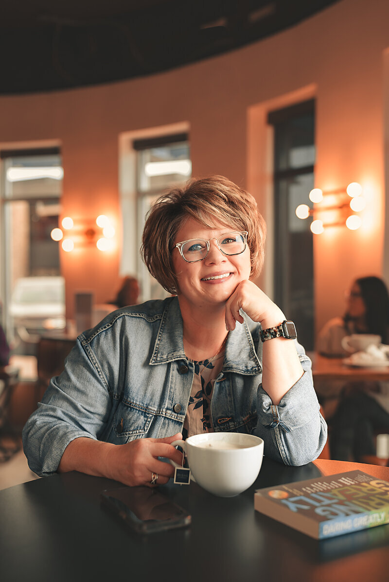 After photo of client relaxed and confident at a café, smiling while holding a coffee mug during her professional dating portrait session with Shannon Kathleen Photography.