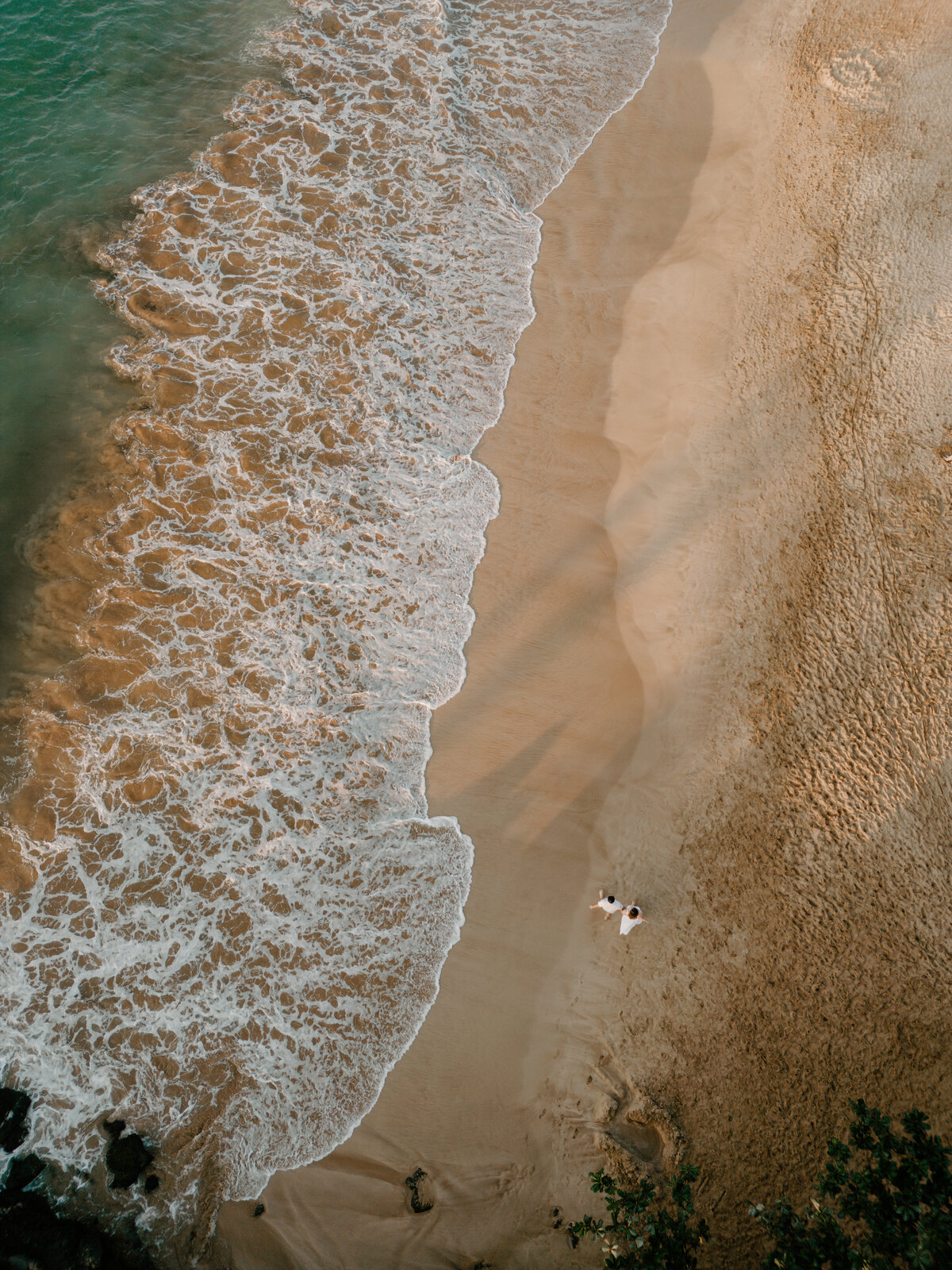 Hawaii Engagement Photographer captures couple walking on beach with drone photos