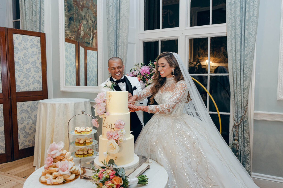 A wedding photo showing the couple cutting their wedding cake at Luttrellstown Castle in Ireland