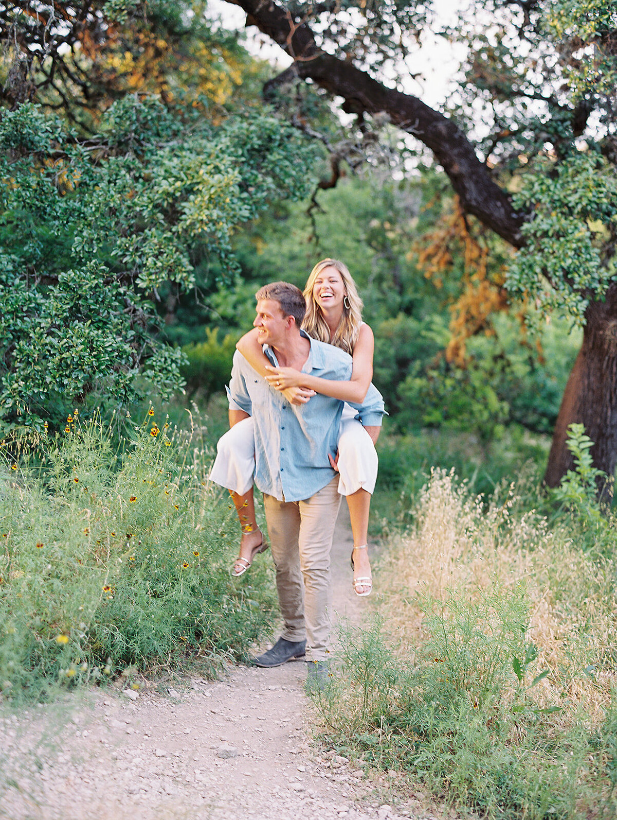 Man holding woman on his back in a grassy field