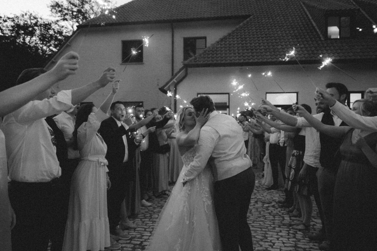 Bruid en bruidegom geven een kus en lopen door erehaag met sterrenstokjes. Sparkles exit foto.