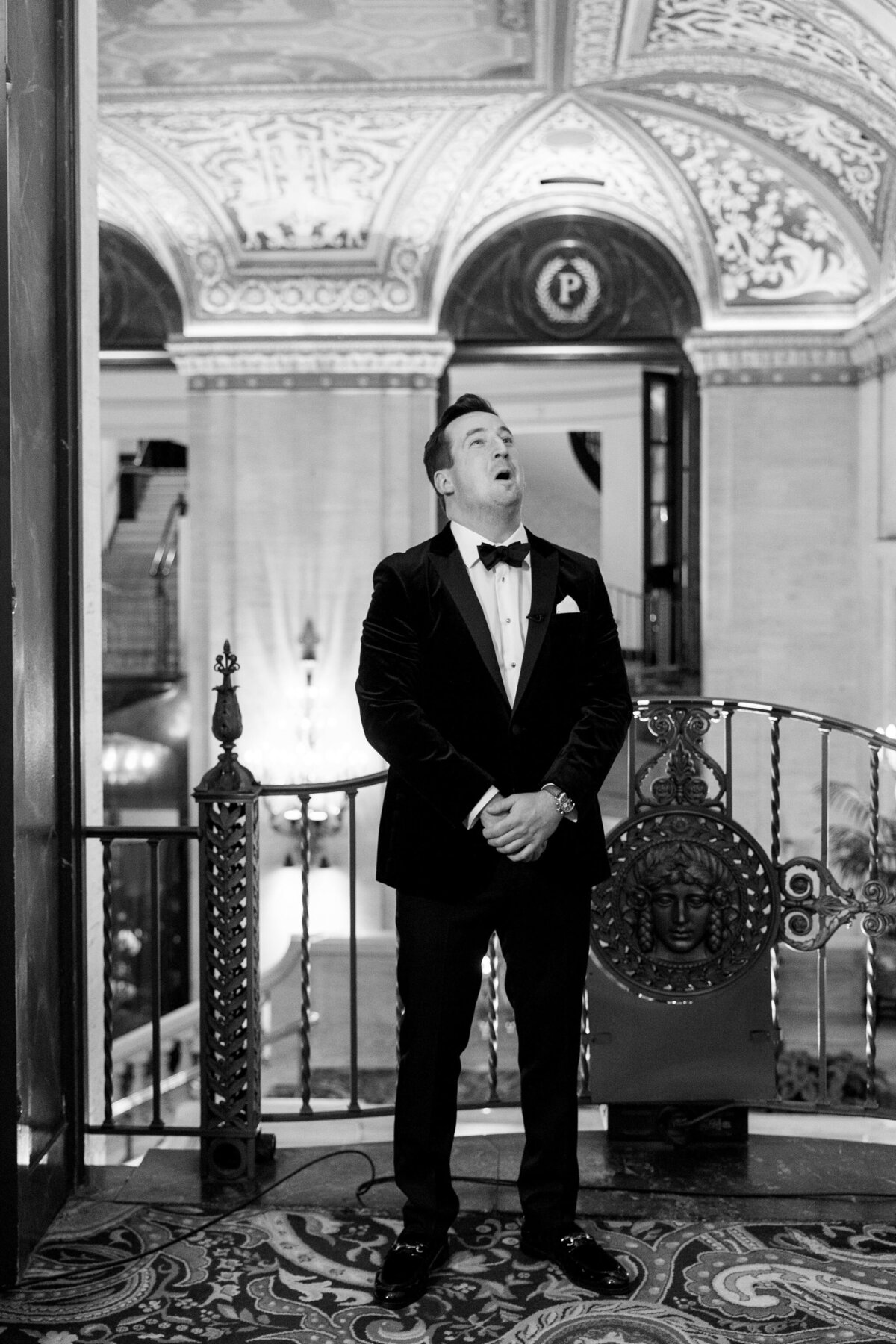 A black and white image of the excited groom standing in the Palmer House Chicago. 