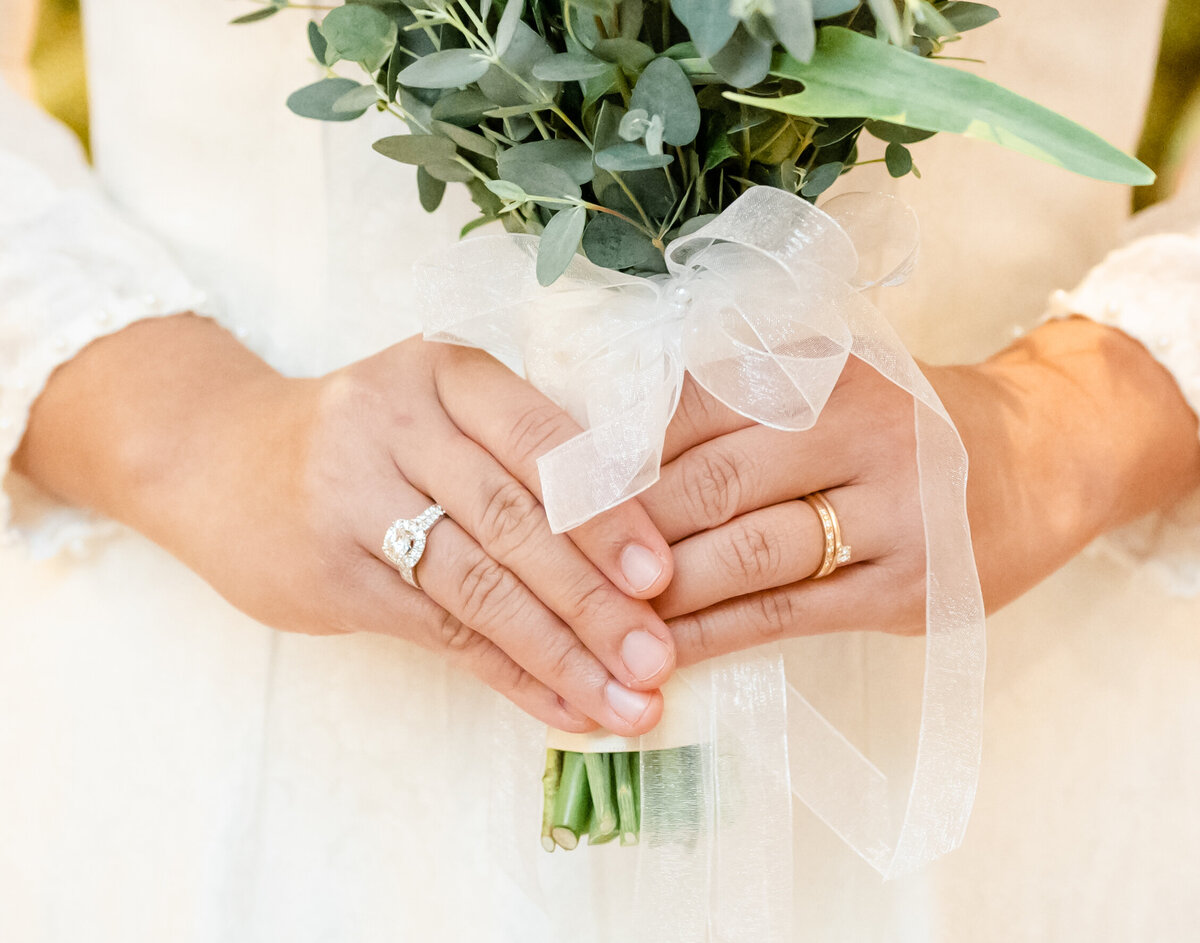 Detailed image of bride holding her bouquet showcasing the rings