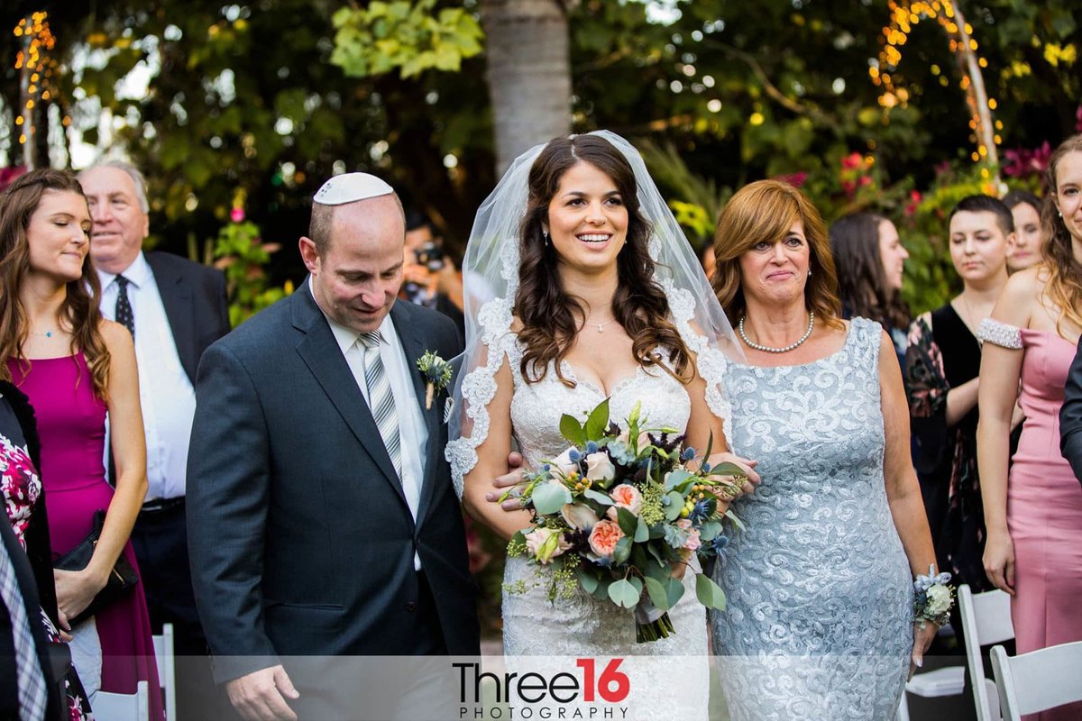 Bride walking down the aisle with her parents