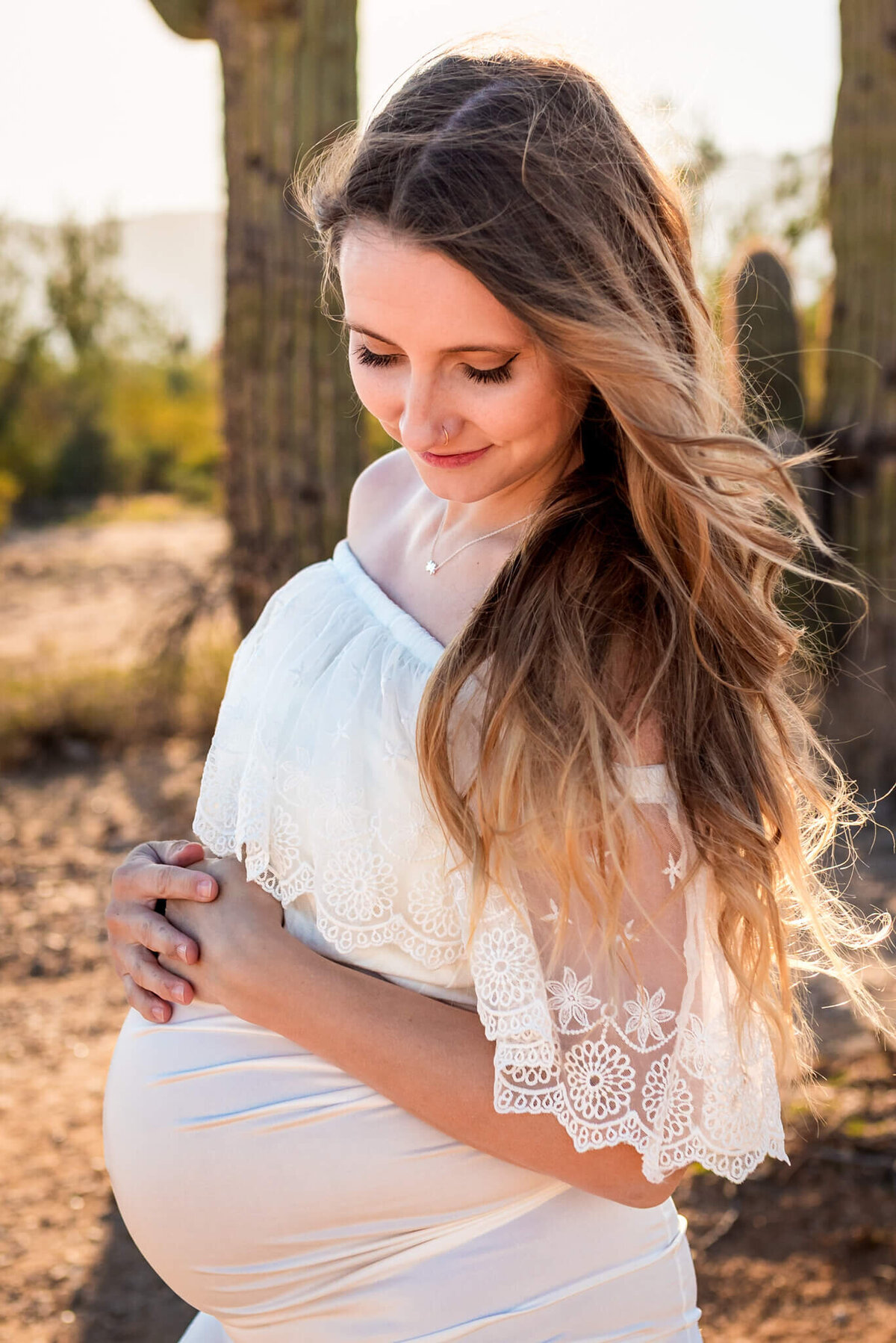 mom-to-be looking beautiful in white maternity dress with lace. Photographed in Arizona