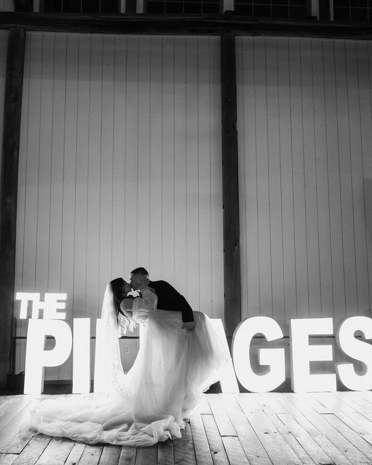 Alphalit lighted name letters in a black and white image of the interior of the Willowbrook wedding venue with a bride and groom dancing