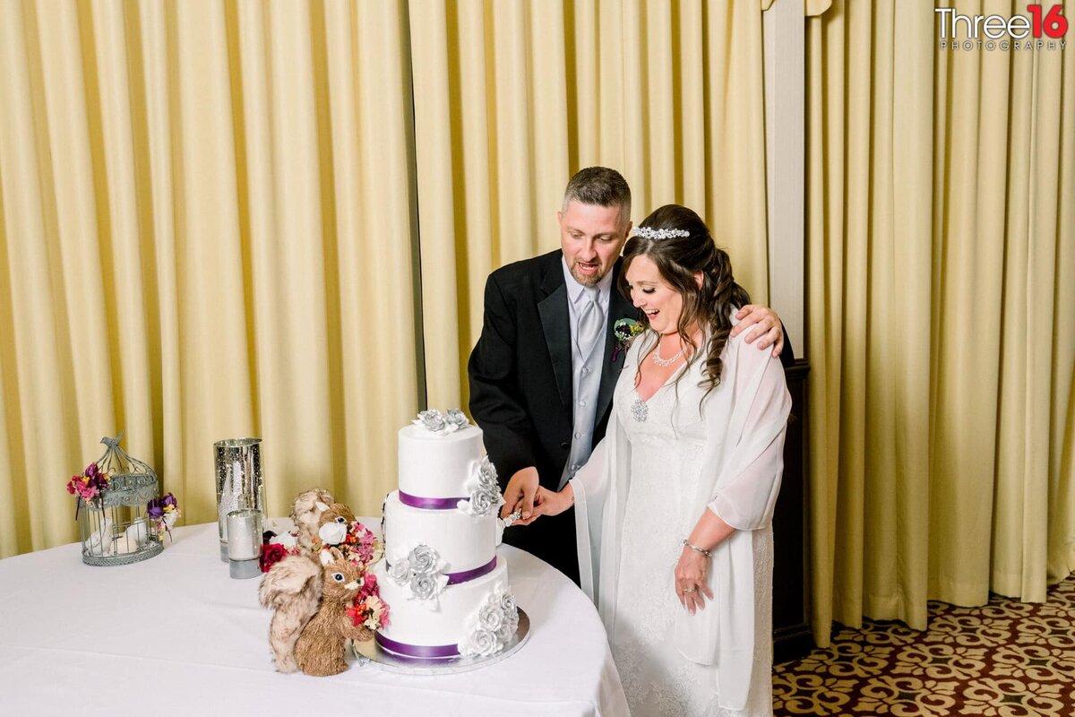 Bride and Groom cut into a beautiful 3-tiered wedding cake