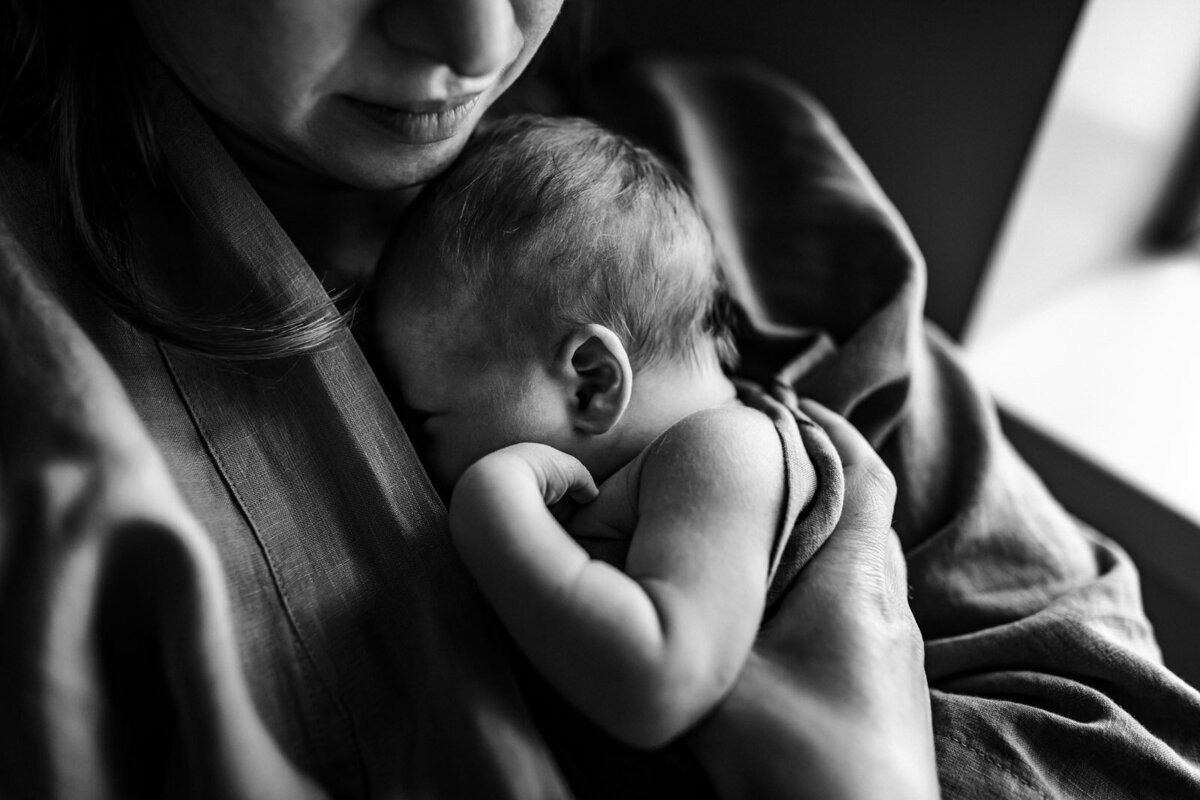 newborn snuggled into mom's chest and sleeps