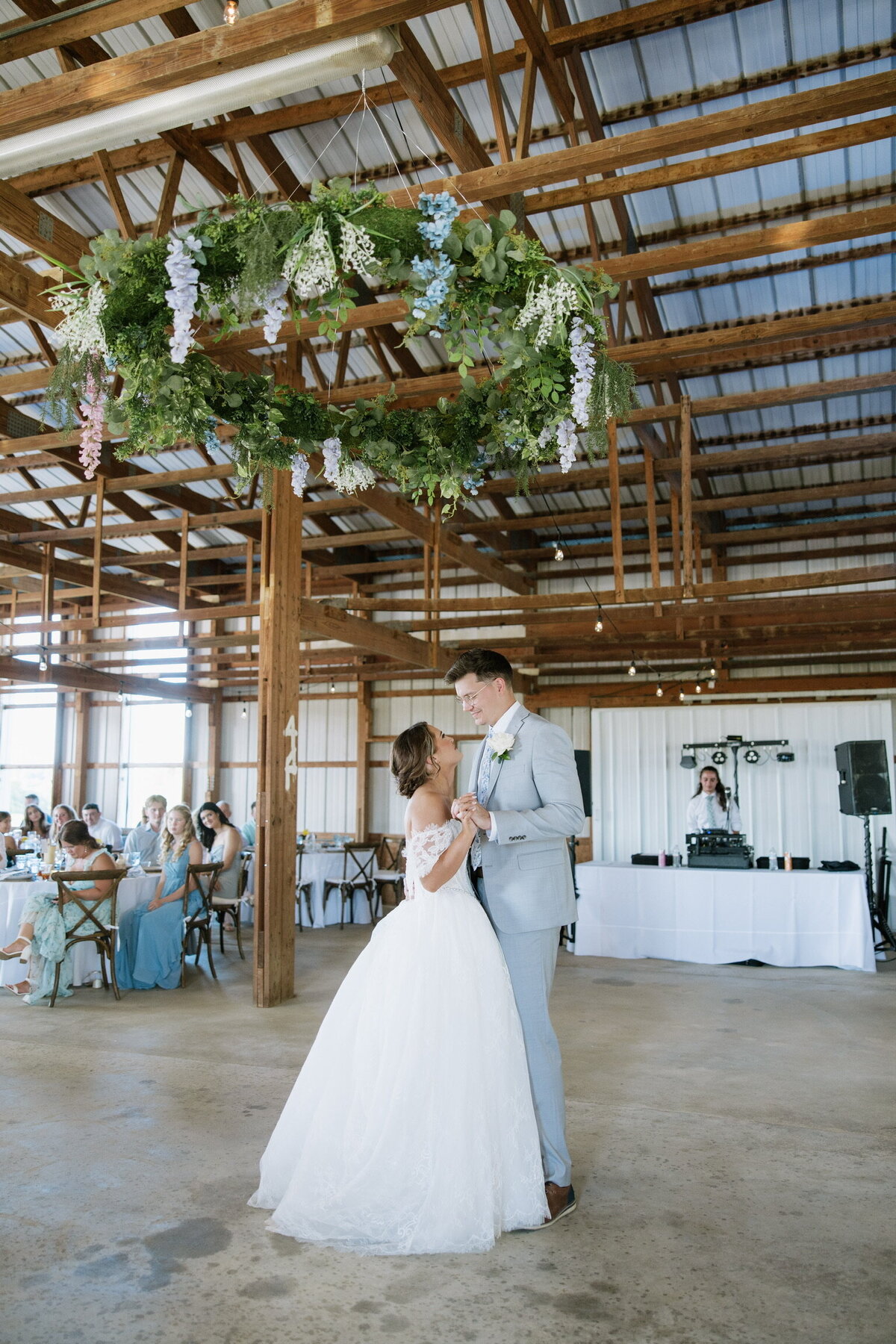 Bride and groom share first dance inside indoor barn reception hall at Willstone Acres wedding venue