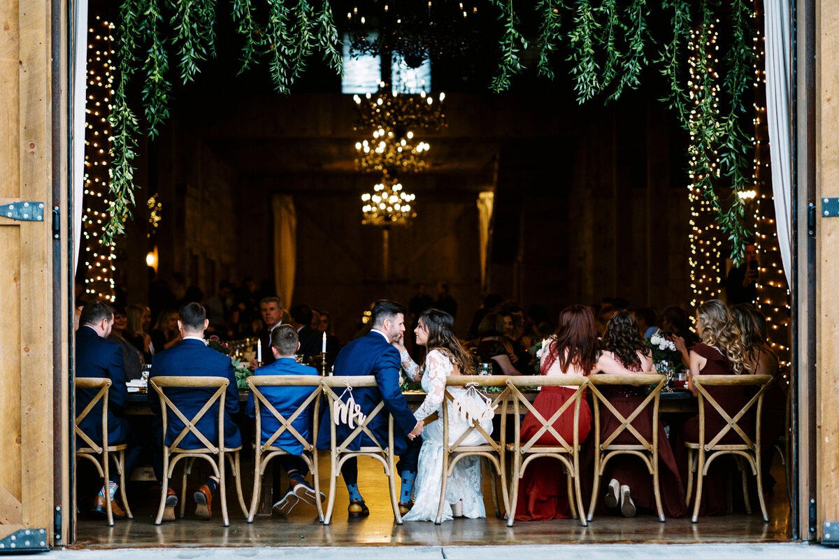 bride and groom sitting in the barn holding hands  at Creekside Farm Weddings & Events