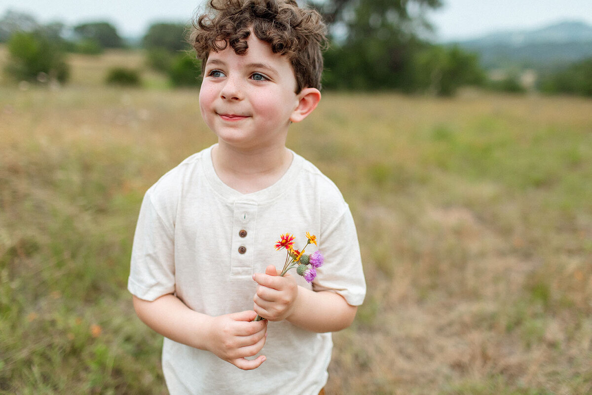 Portrait of a young boy outdoors, captured by Sara James, a San Antonio family photographer.