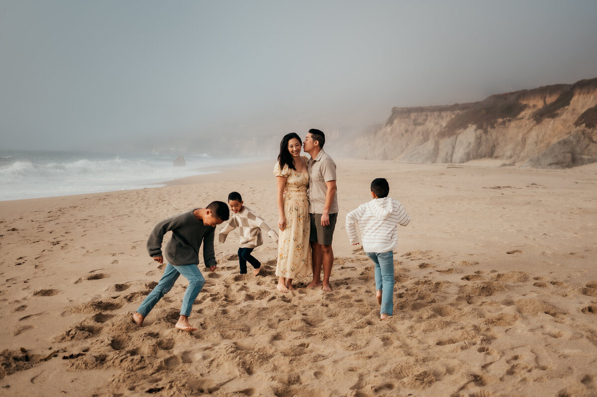 Family playing together on a foggy Carmel beach