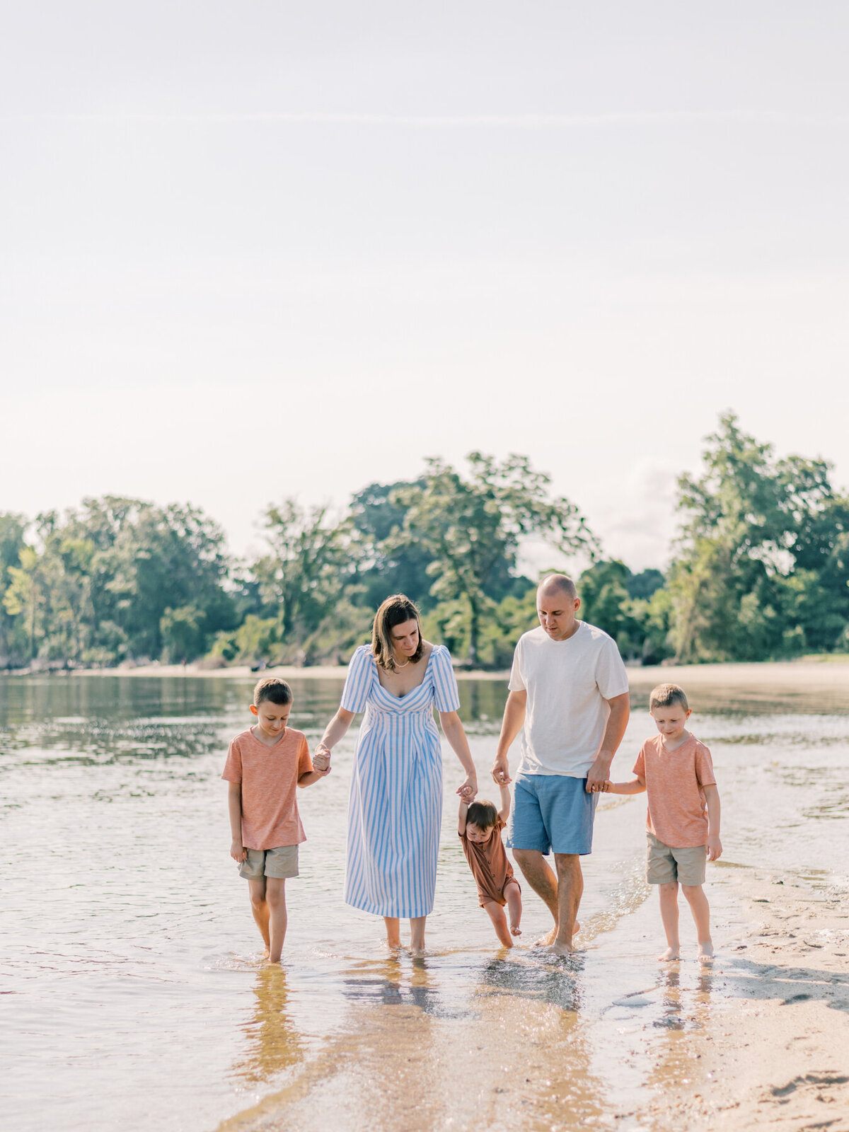 Young growing family walking the beach in Virginia.