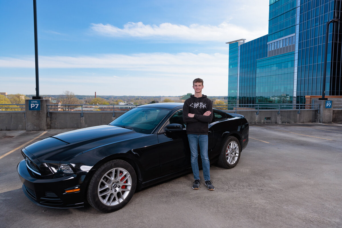 High School Senior guy with his mustang on a Raleigh rooftop.