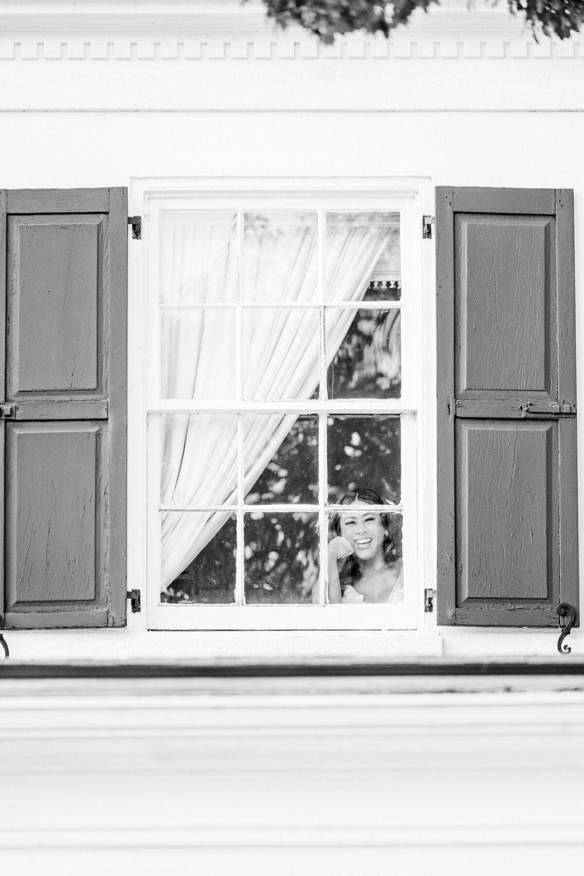 bride peeking out a window at Legare Waring House